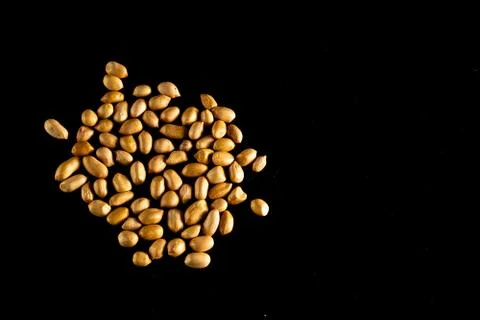 Peanuts spread out on a dark table Stock Photos