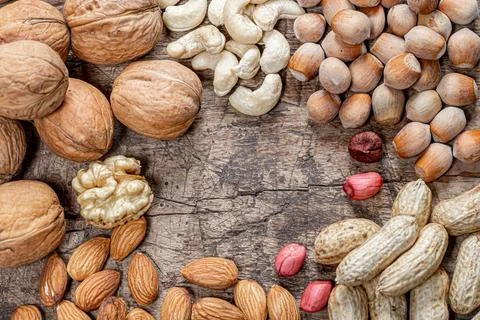 Peanuts, walnuts, almonds, cashews and hazelnuts on old wooden background Stock Photos