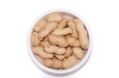 Peanuts in a white cup on a white background Stock Photos