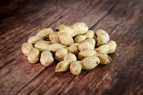 Peanuts on wooden background, composition of nuts, food background Stock Photos