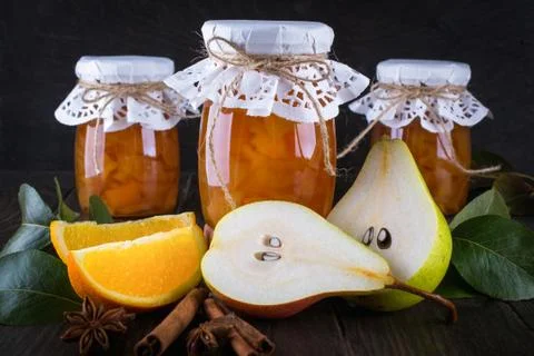 Pear and orange jam in  glass jars with ripe pears, cinnamon sticks Stock Photos