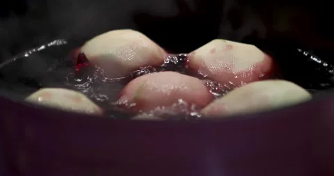Pear boiling in syrup in frying pan on gas stove Stock Footage 157573623