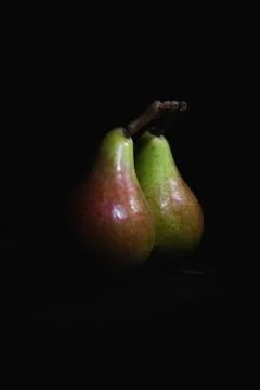 Pear fruit reflecting in a mirror, black dark background Stock Photos