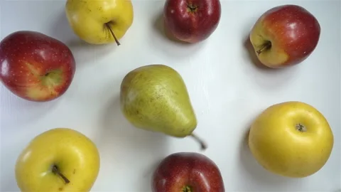 Pear rotates in a circle of apples in slow motion Video stock 151113636