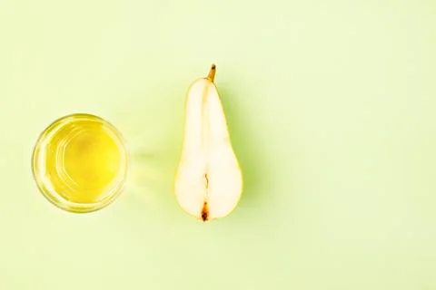 Pear split in half, pear lemonade in glass Cup on green background. The view  Stock Photos