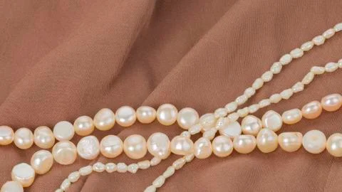 Pearl beads on brown cloth Stock Photos