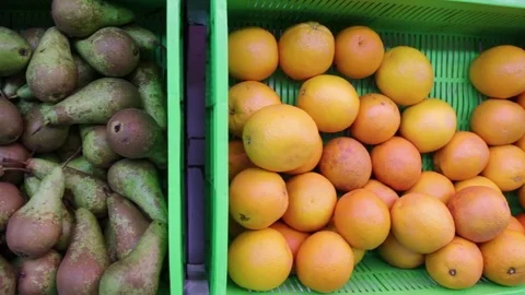 Pears and oranges lie in the basket on the market Stock Footage 83750144