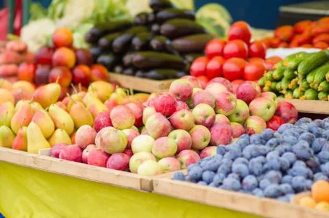 Pears, apples, plums, cucumbers, tomatoes, eggplants in city market Stock Photos