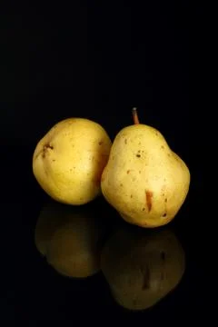 Pears on a black background with reflection Stock Photos