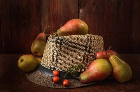 Pears in bulk on an old hat on a dark wooden background in a rustic style Stock Photos