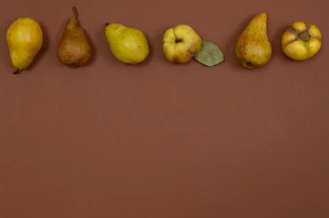 Pears in row on brown background with copy space Stock Photos