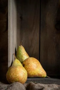 Pears in rustic kitchen setting with wooden box and hessian sack Stock Photos