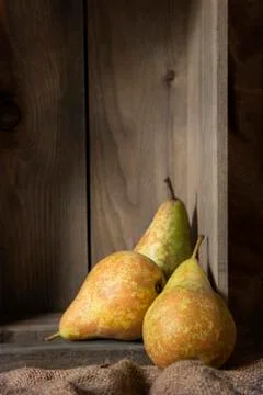 Pears in rustic kitchen setting with wooden box and hessian sack Stock Photos