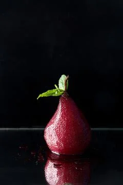 Pears in wine. Row of raditional dessert pears stewed in red wine on black ba Stock Photos