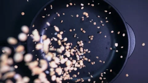 Peas falling into a frying pan in super slow motion Stock Footage 280685314