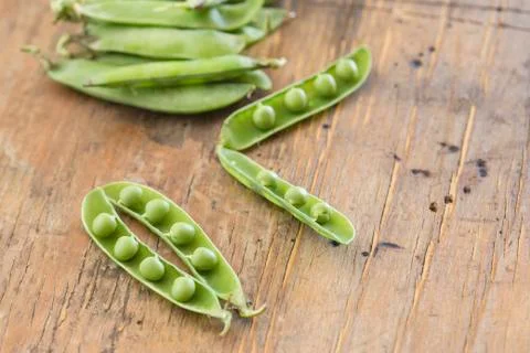Peas in a wooden table Stock Photos