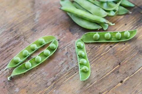 Peas in a wooden table Stock Photos