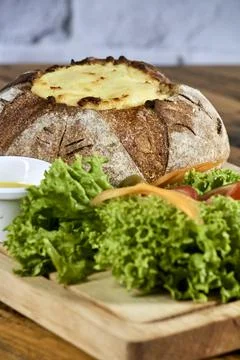 Peasant bread stuffed with meat and chicken covered with cheese with salad Stock Photos