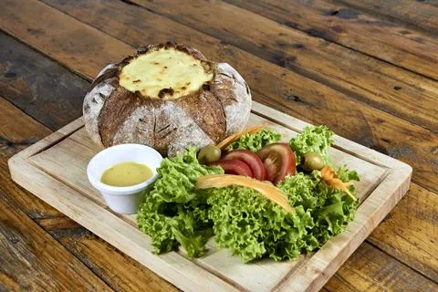 Peasant bread stuffed with meat and chicken covered with cheese with salad Stock Photos