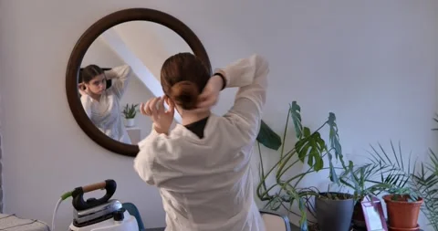 Peasant hairstyle in front of circular mirror. Stock Footage 327844487