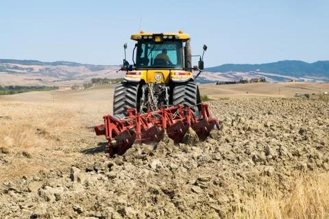 Peasant on the tractor while preparing the field for sowing Stock Photos