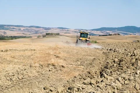 Peasant on the tractor while preparing the field for sowing Stock Photos