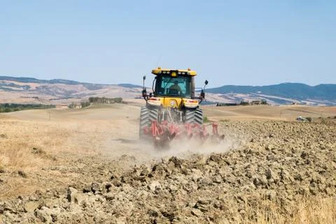 Peasant on the tractor while preparing the field for sowing Stock Photos