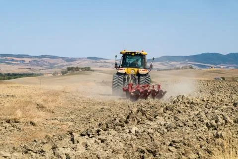 Peasant on the tractor while preparing the field for sowing Stock Photos
