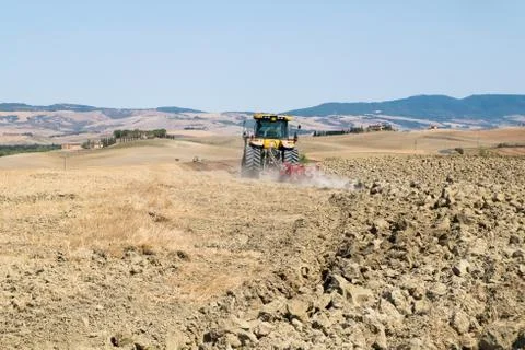 Peasant on the tractor while preparing the field for sowing Stock Photos