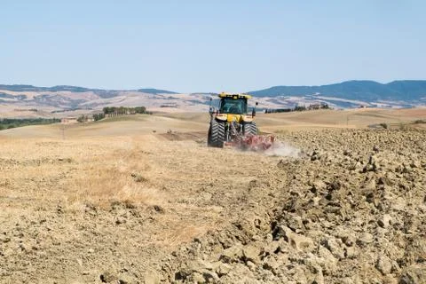 Peasant on the tractor while preparing the field for sowing Stock Photos