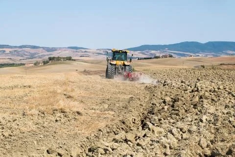 Peasant on the tractor while preparing the field for sowing Stock Photos