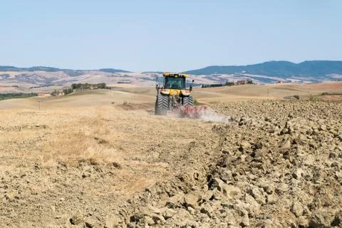Peasant on the tractor while preparing the field for sowing Stock Photos