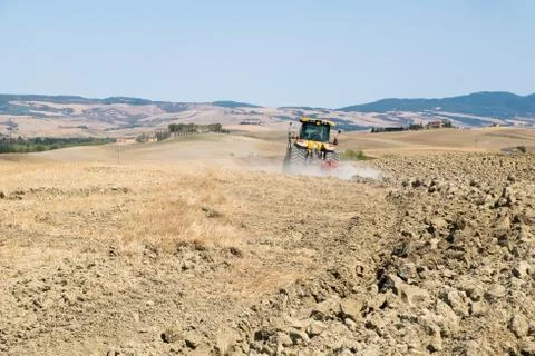 Peasant on the tractor while preparing the field for sowing Stock Photos
