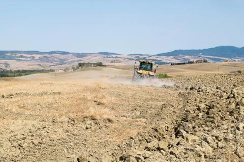 Peasant on the tractor while preparing the field for sowing Stock Photos