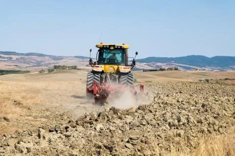 Peasant on the tractor while preparing the field for sowing Stock Photos