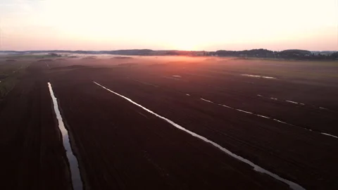 Peat extraction site in fog on sunset. Collecting peat on peatlands. Vídeo Stock 219825520