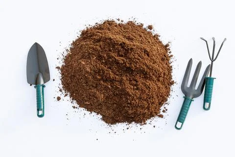 Peat with garden tools on a white background. Fertile soil of dark color. Stock Photos
