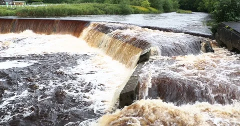 Peat stained water going over a weir in the River Ribble after heavy rain in  Stock Footage 255935198
