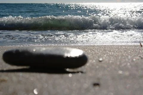 A pebble and a wave Stock Photos