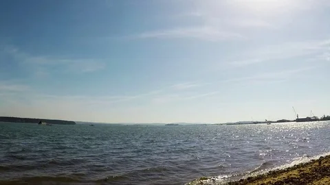Pebble beach with algae over the ocean, beautiful blue water Stock Footage 78517279