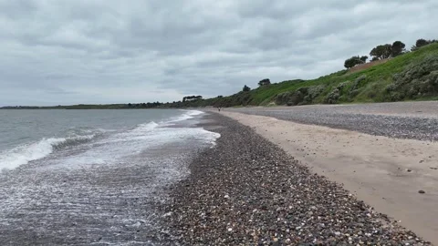 Pebble Beach and Gentle Waves Along the Coast Stockbeeldmateriaal 337848121