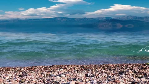 Pebble beach and mountain peaks 動画素材 337705058
