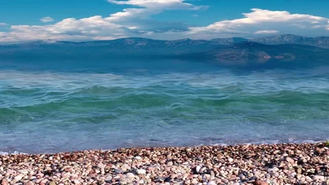 Pebble beach and mountain peaks Video stock 337705262