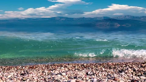 Pebble beach and mountain peaks Video stock 337705284