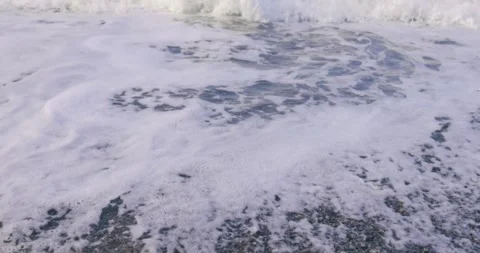 Pebble beach and sea wave with white foam close-up Stock Footage 258670801
