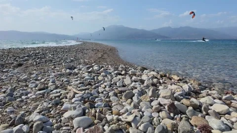 Pebble Beach Macro View With Kitesurfers on Greek Island in Summer Stock Footage 337046345