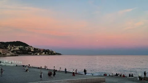 Pebble beach in Nice at sunset with people relaxing Stock Footage 336923300