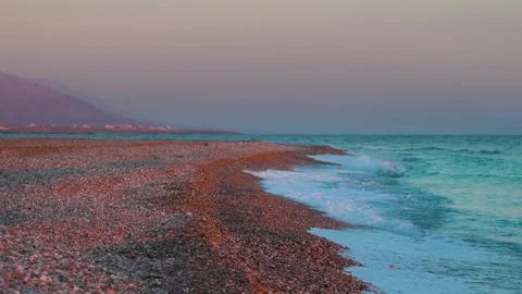 Pebble Beach in Oman with Waves at Sunset Stock Footage 318824524