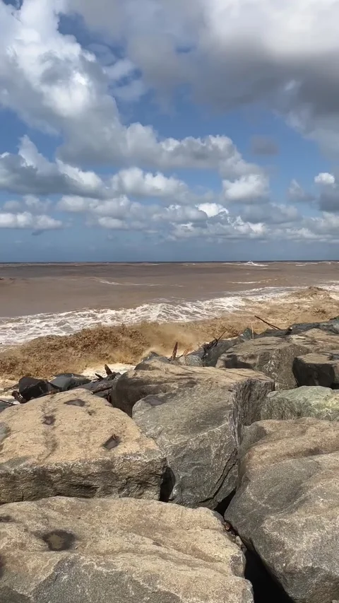A pebble beach polluted with plastic waste, with the coastline after a storm  動画素材 341759653