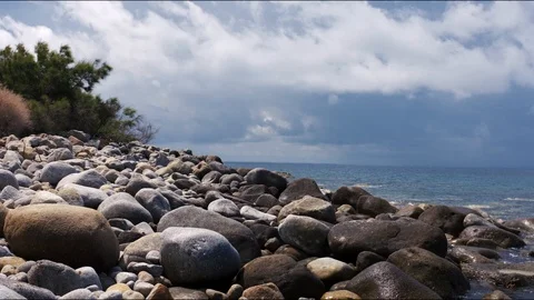 Pebble beach shot with rocks in foreground. Handheld shot. Stock Footage 93792820
